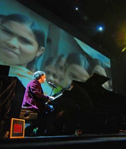 Peter Buffett playing the piano in concert