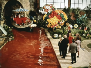 People walking through an inside garden with boat canal